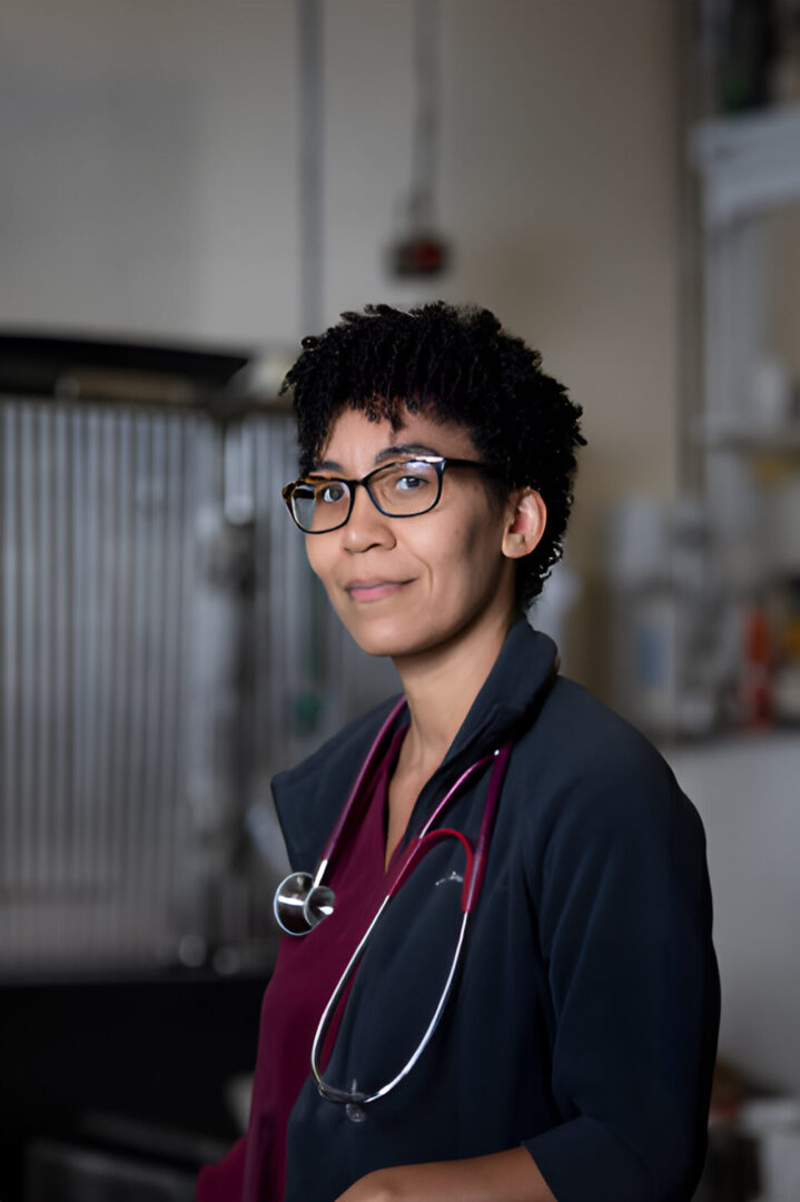 A woman with glasses and a stethoscope around her neck.