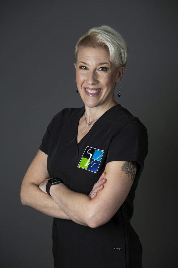 A woman with her arms crossed wearing a black shirt