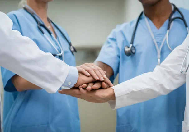 Two doctors holding hands in a circle